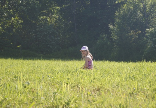 Kind sitzt in der Wiese