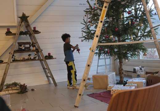 Kind dekoriert den Weihnachtsbaum