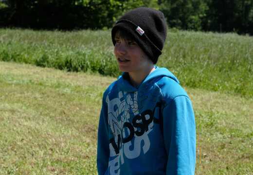 Kind steht auf der Wiese